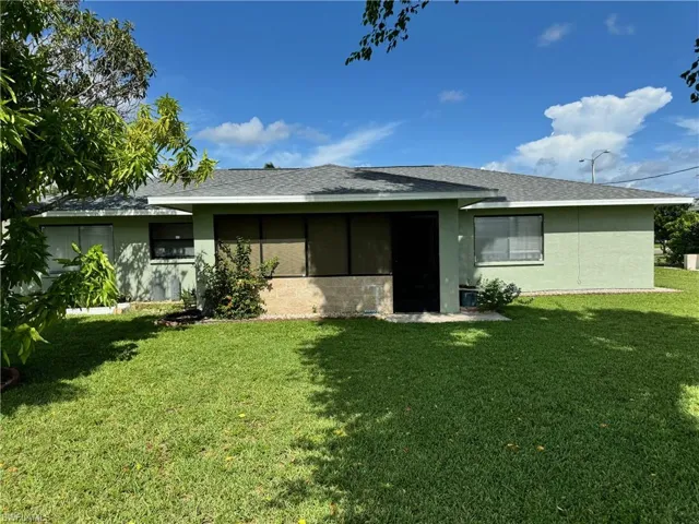 Back of house featuring a lawn