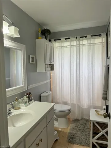 Bathroom with tile patterned floors, vanity, and toilet