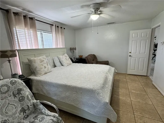Bedroom with ceiling fan and light tile patterned floors