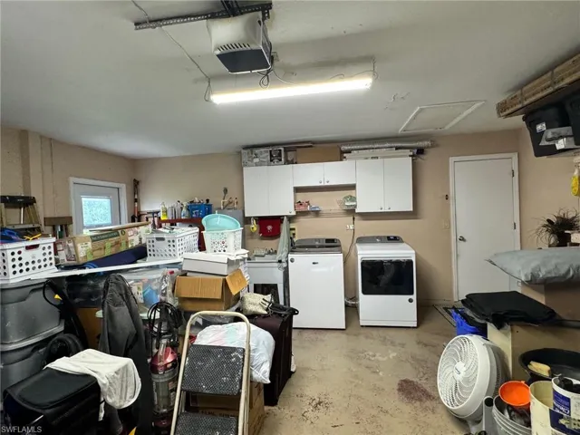Garage with a garage door opener and washer and clothes dryer