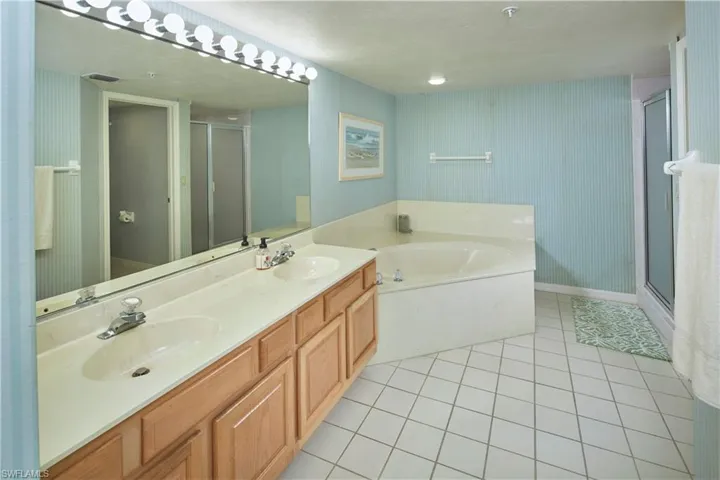 Primary en suite bathroom with dual sinks, walk in shower and soaking tub.