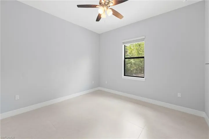 Room featuring light-colored walls, a ceiling fan, and a window providing natural light