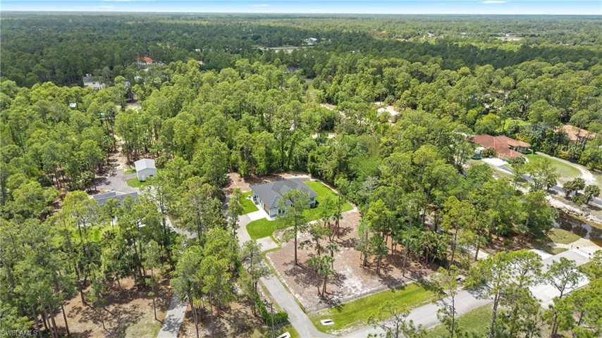 The property features a well-maintained exterior with a driveway, set within a lush, treed environment