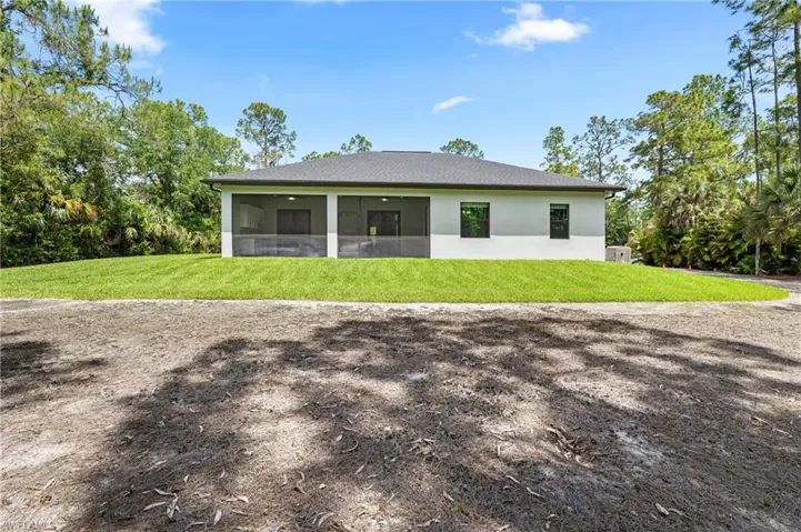 The property features a white exterior with a dark roof and a screened-in patio