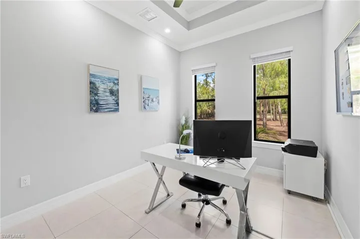 This room offers views of mature trees, recessed lighting, a ceiling fan, and tile flooring