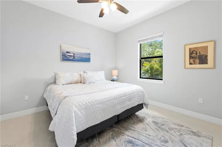 This room features light-colored walls and flooring, with a window offering views of green foliage