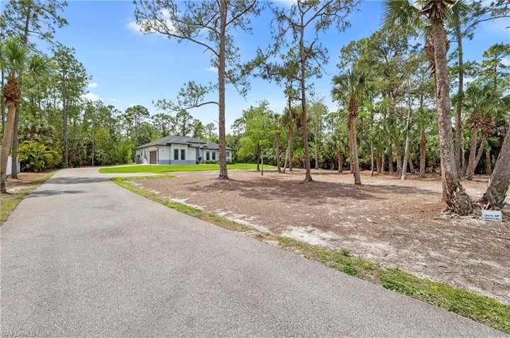 The property features a well-maintained paved driveway leading to a modern-style residence with a two-car garage