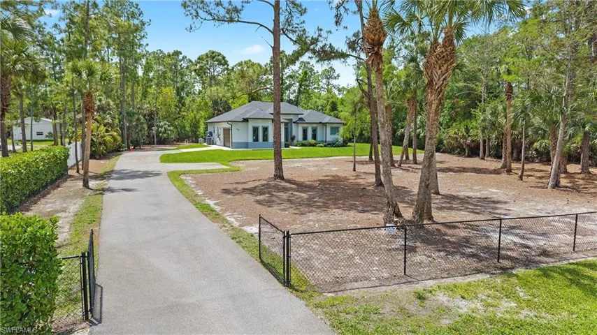 The property features a gated entrance leading to a paved driveway