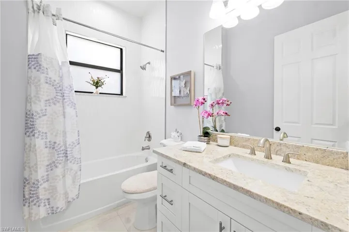 Bathroom featuring a vanity with a light-colored countertop, an integrated sink, and a large mirror
