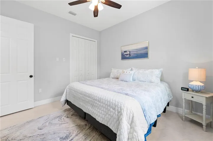 Bedroom featuring light-colored walls and carpeted flooring, with a ceiling fan