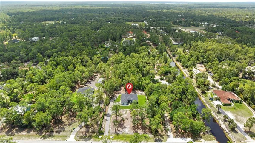 Aerial view showcasing the property nestled amongst a dense tree canopy