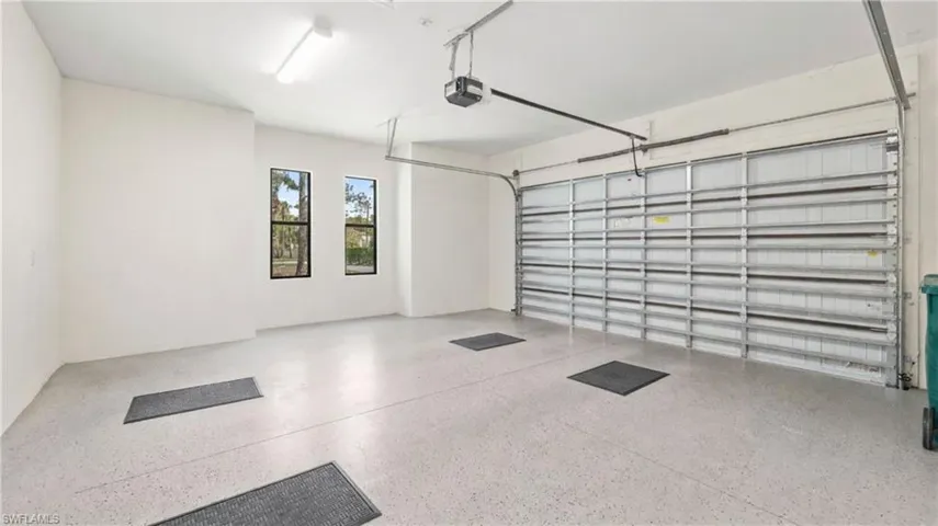 The garage features a light-colored floor, a garage door with an automatic opener, and two windows