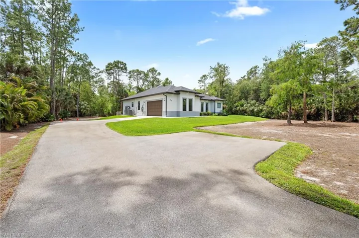 The property features a concrete driveway leading to a modern-style residence with a two-car garage