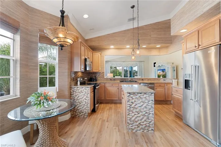 Kitchen featuring wood-finish flooring, light wood cabinetry, and stainless steel appliances