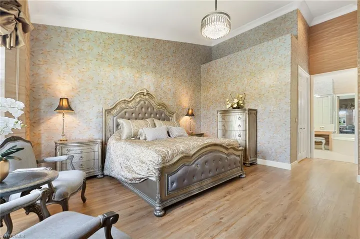 Spacious room featuring vaulted ceilings, wood-finish flooring, and decorative wallpaper