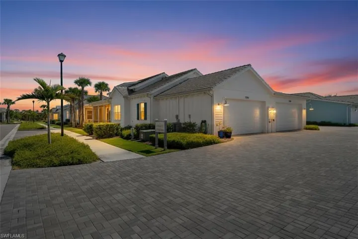 Ranch-style house featuring an attached garage and decorative driveway