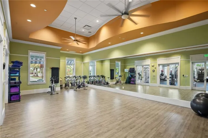 Workout area featuring a towering ceiling, a ceiling fan, recessed lighting, and crown molding