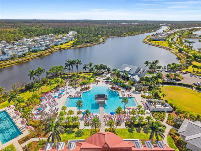 Aerial perspective of suburban area with a pool area and a large body of water