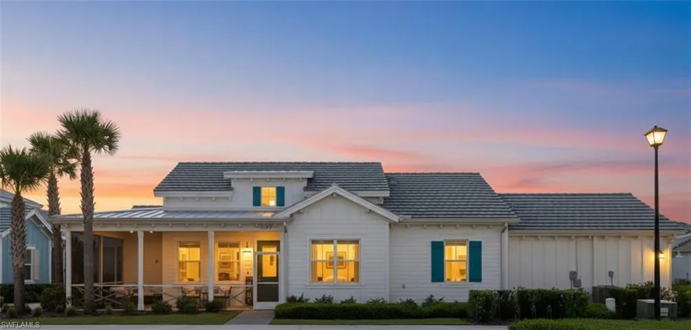 Back of property at dusk with board and batten siding and a lawn