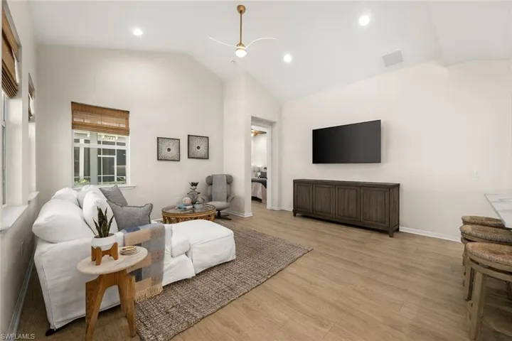 Living room featuring wood finished floors, a ceiling fan, high vaulted ceiling, and recessed lighting
