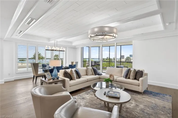Coastal contemporary vibe throughout the living room and dining room space. The wall of floor to ceiling windows and glass slidiers sheds lots of natural light