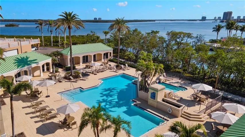 Resort-style pool with water view and sun-deck seating.