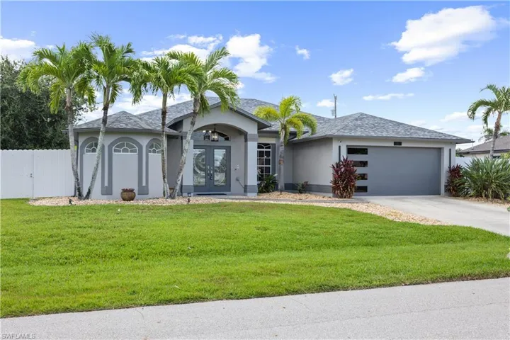 Single-story residence featuring a gray exterior, a two-car garage with horizontal windows, and a concrete driveway