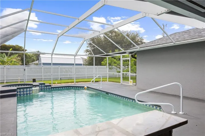 Screened lanai featuring a swimming pool and built-in spa with decorative tile accents