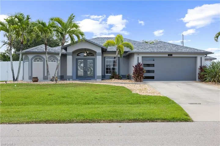 Contemporary single-story residence with a gray exterior, a gray shingled roof, and a modern garage door with frosted glass panels