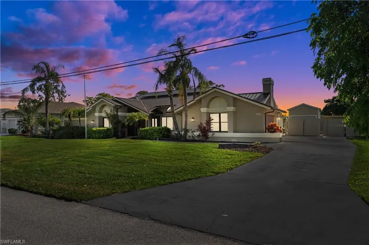 Single story home with a chimney, a front lawn Sunset Hour