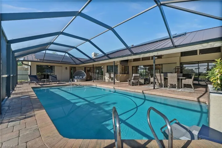 Outdoor pool featuring a patio, outdoor dining area, a lanai, and ceiling fan