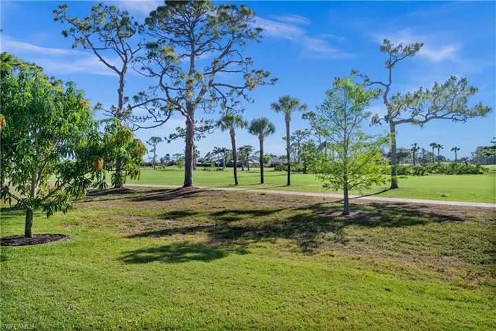 Surrounding community featuring a lawn and view of golf course
