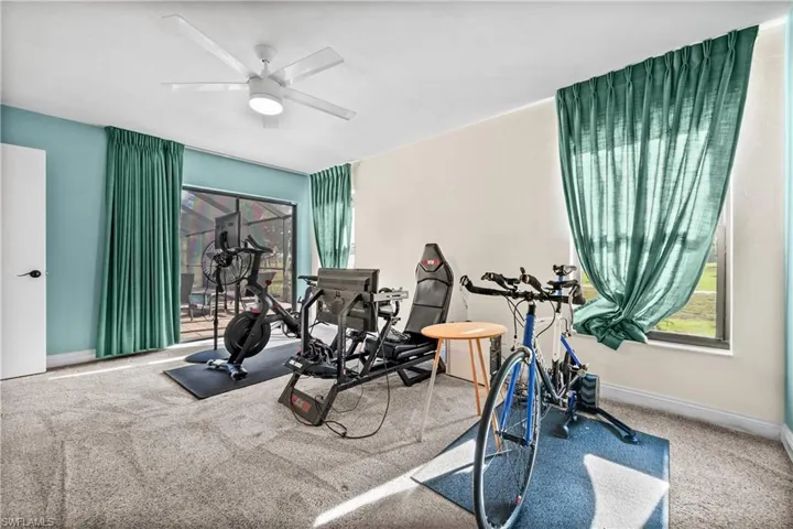 Workout area with ceiling fan, and carpet flooring