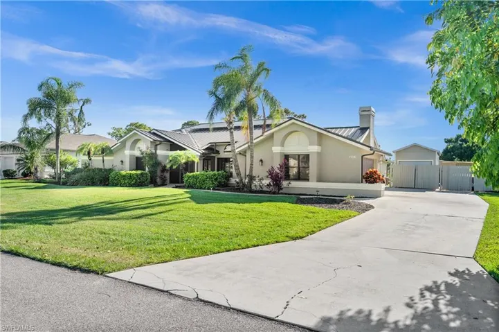 Ranch-style house featuring stucco siding, driveway, and a chimney