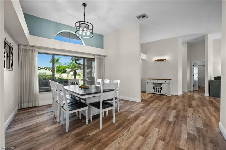 Dining space featuring wood finished floors, a chandelier, and baseboards