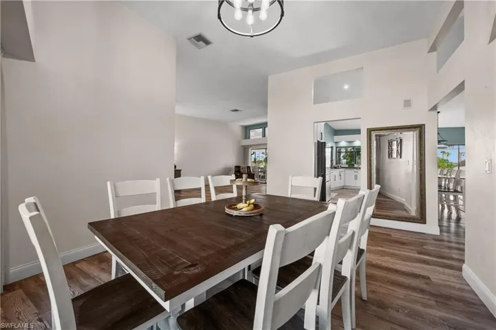 Dining room with wood finished floors, baseboards, and a chandelier