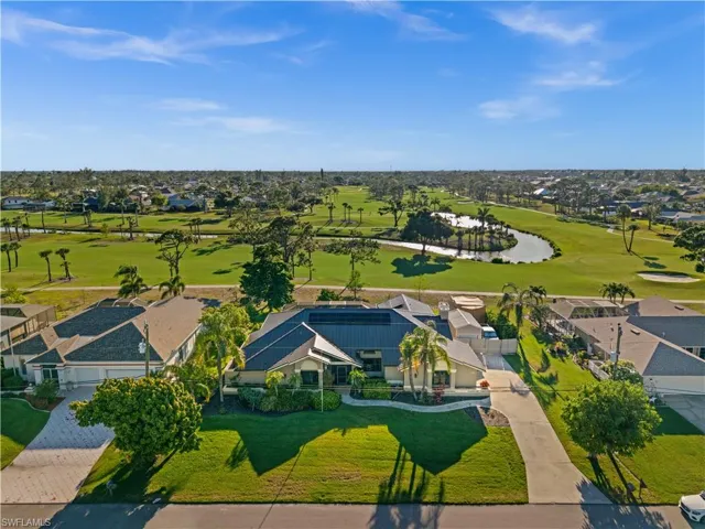 Aerial view of residential area featuring a golf club and a nearby body of water