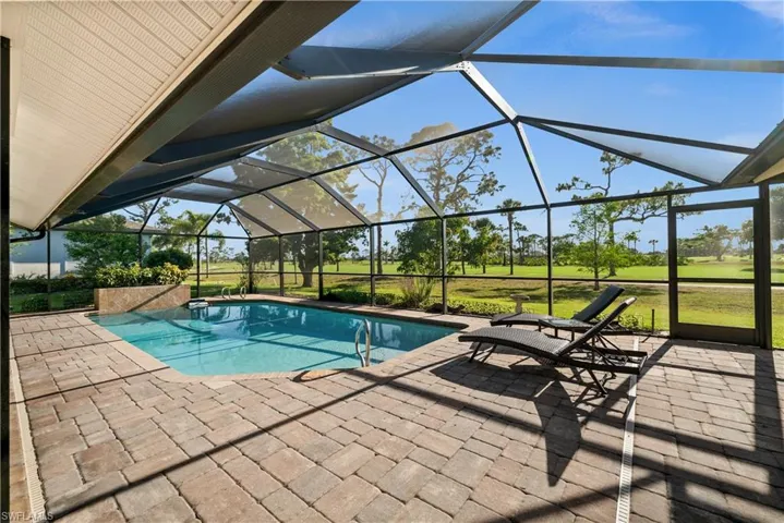 Outdoor pool featuring a patio area, a lanai, and a lawn