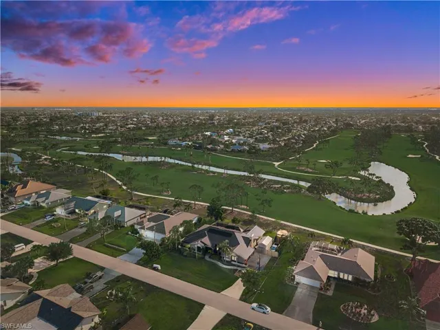 Aerial view of property's location with a large body of water, nearby suburban area, and a local golf course