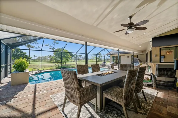 View of patio featuring an outdoor pool, a ceiling fan, a lanai, and outdoor dining space