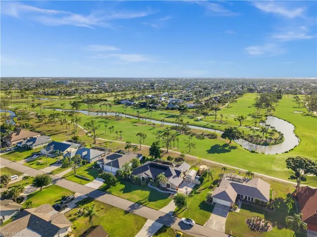 Aerial overview of property's location featuring nearby suburban area, a large body of water, and a golf club