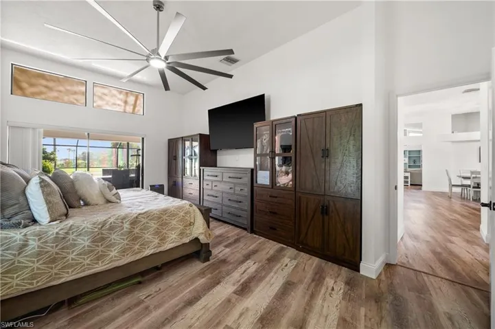 Bedroom featuring a high ceiling, wood finished floors, and a ceiling fan
