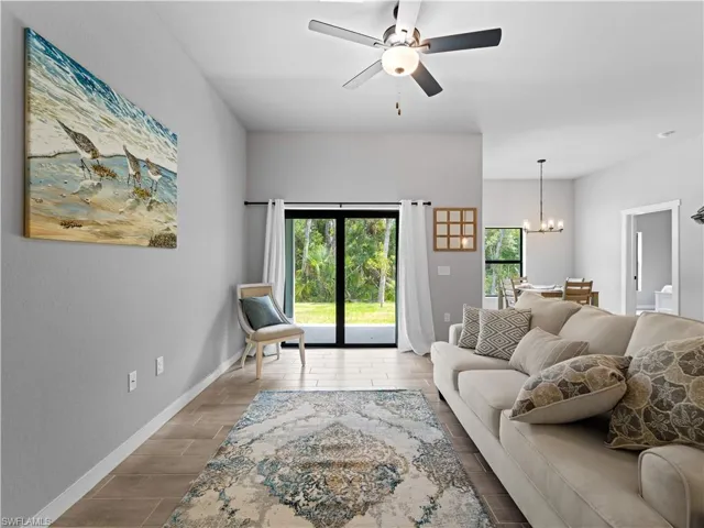 Living room with hardwood / wood-style floors and ceiling fan with notable chandelier
