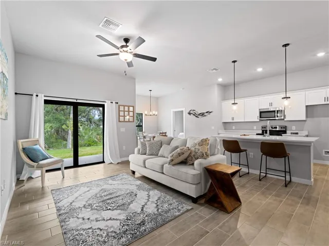 Living room with ceiling fan with notable chandelier