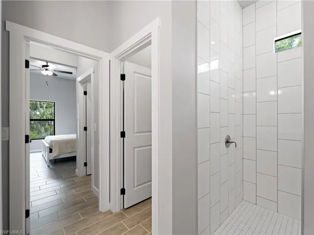 Bathroom featuring a tile shower and ceiling fan