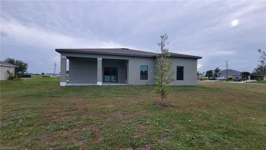Back of house with a lawn