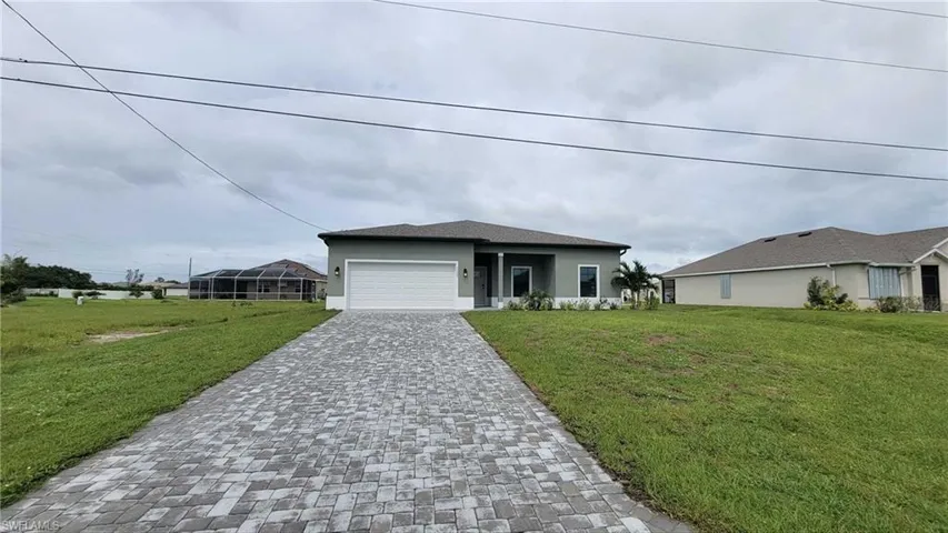 View of front of property with a front lawn and a garage