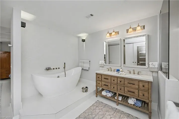 primary bathroom looking at soaking tub and entrance to primary bedroom
