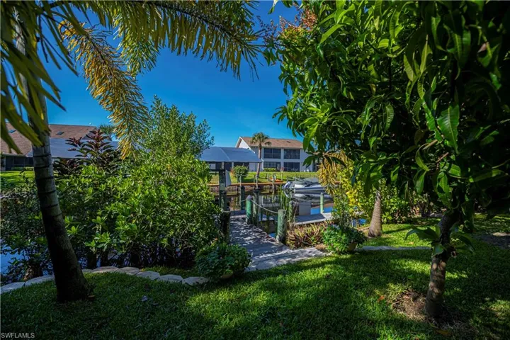 backyard looking down to canal and composite dock, with canopy and lift
