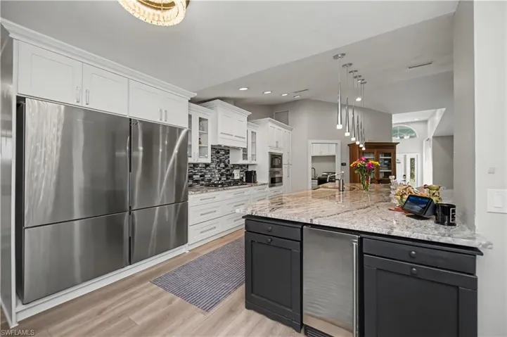 looking into kitchen from the den/office featuring double fridge/ freezer and separate ice maker